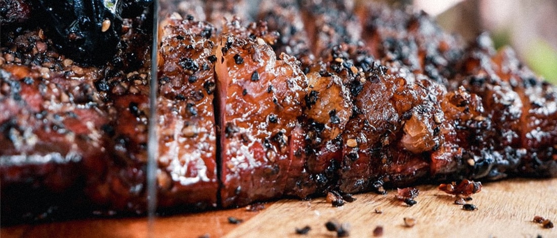 Cutting a smoked meat in a chopping board