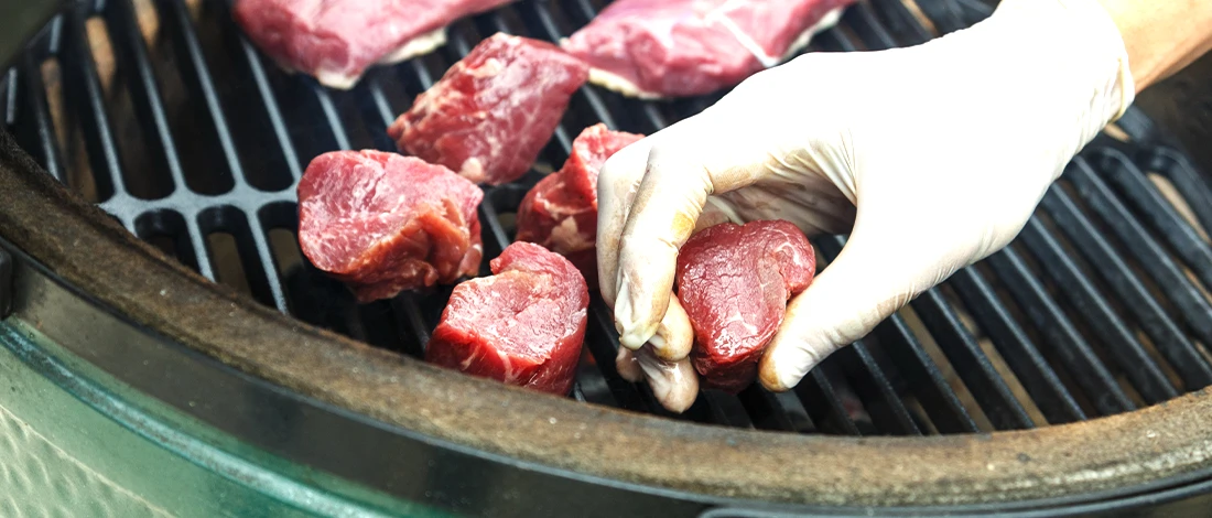 Using a glove to put meats on grill