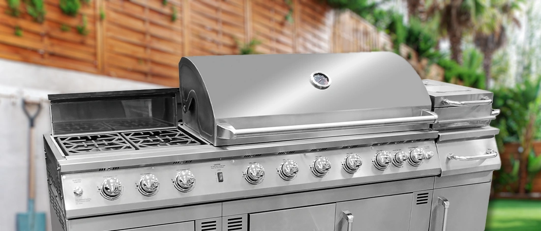 A wide gas grill in the backyard