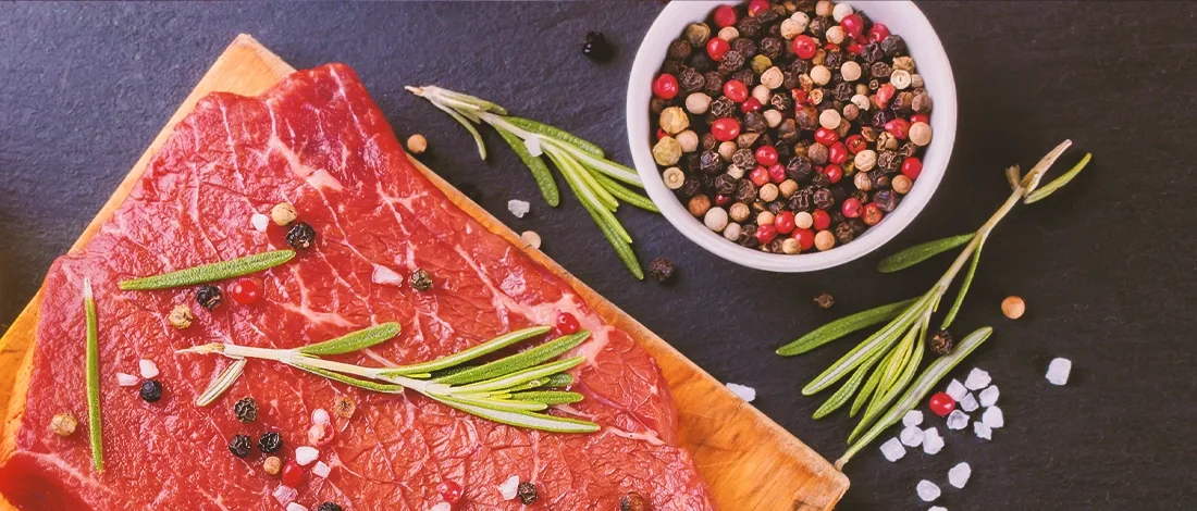 Top view of raw meat beside seasoning