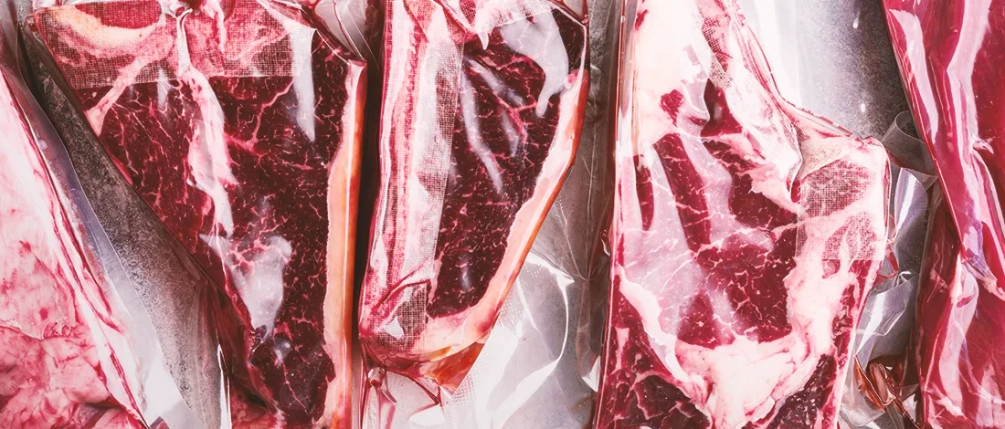 Vacuum sealed pieces of meat on a white table
