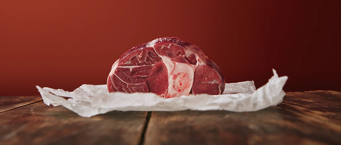 A raw piece of meat on top of white paper packaging