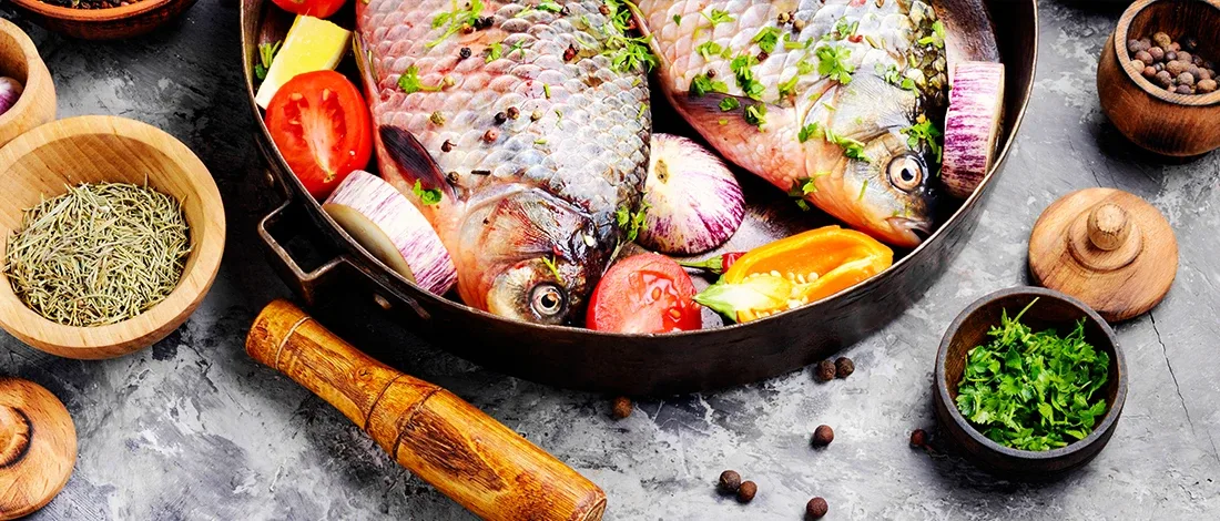 Two uncooked fish in a pan with spices