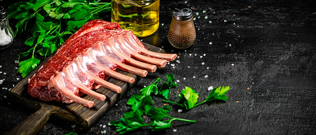 An image of raw rack lamb on a cutting board