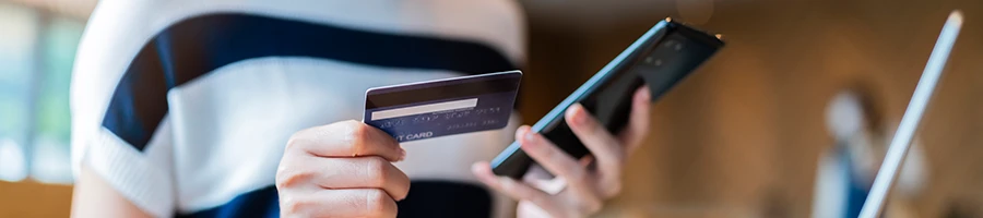 A woman browsing for best tail gate grill using a phone