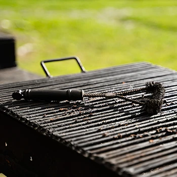 An image of a grill and brush on top for cleaning
