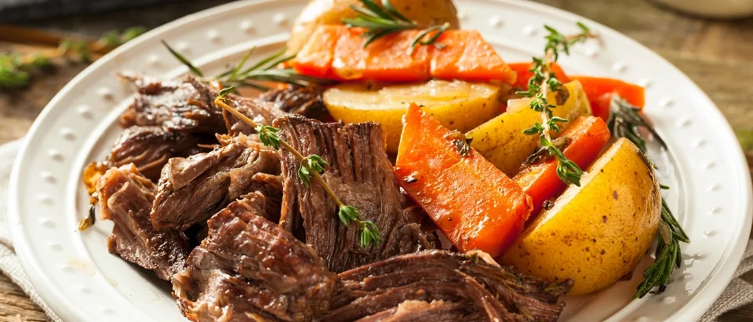 A delicious chuck roast on a white plate