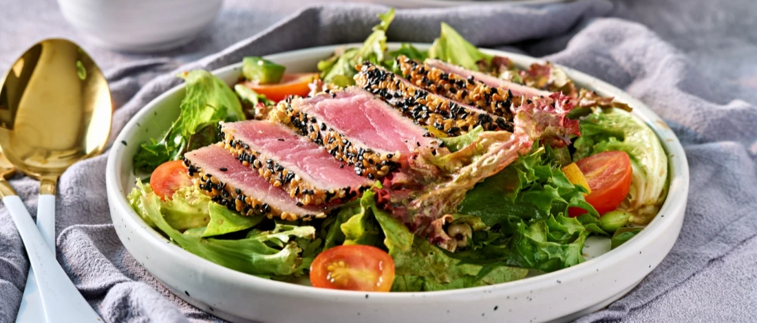 A seared Albacore tuna steak on a white plate